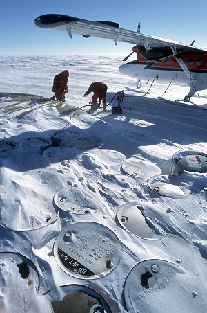 [MidPointCharlieRefueling2.jpg]
6 year later, and there's not much left at Midpoint: the airstrip, a small vehicle to level the snow, an emergency bubble and a stack of snow-covered kerosene drums.