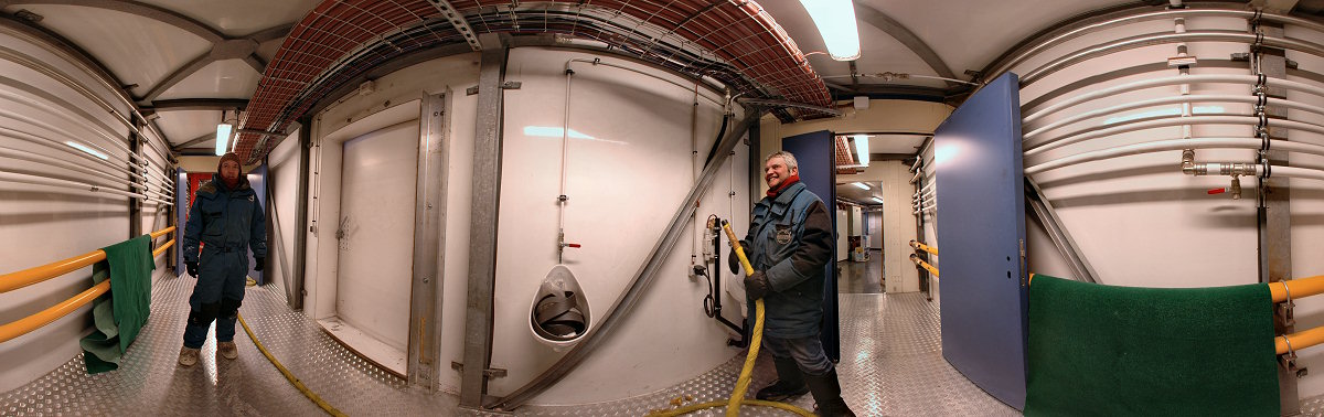 [PanoCorridor.jpg]
Jean and Stef in the corridor joining the power plant (behind Stef) and the noisy building (behind Jean). Since the black water recycling system is not yet operational, a temporary set of urinals has been installed right in the corridor, with its output flowing and freezing in a cardboard tank below. The door between both characters is the least used of the 4 exits of the station.