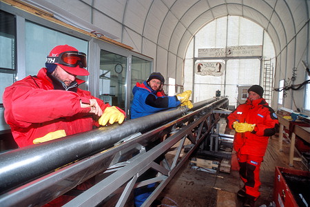 [DrillDisassembly1.jpg]
Disassembling the drill. Several meters long, the drill contains many different parts: a cutting head, an internal space where the ice core slides, anti-return blades to maintain the core in place, side blades to maintain the outer part fixed in the ice while the head and internal screw rotate and bite the ice, a top part with engine and control systems, etc...