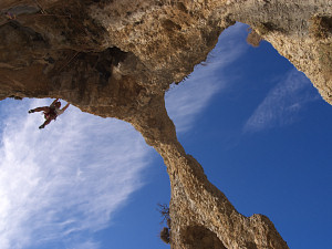 Vincent doing the crux 'drop the feet' move on Room13 (7b)