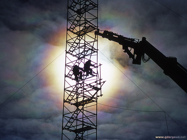 [AmericanMastAssemblyBacklit3.jpg]
Iridescent clouds behind people working on the mast to install new satellite calibration systems.